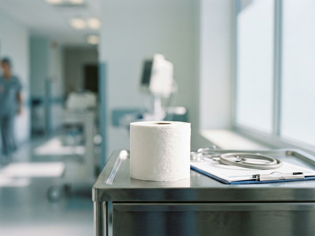 Witte toiletpapierrol op medische kar in ziekenhuis met stethoscoop en klembord, steriele zorgomgeving